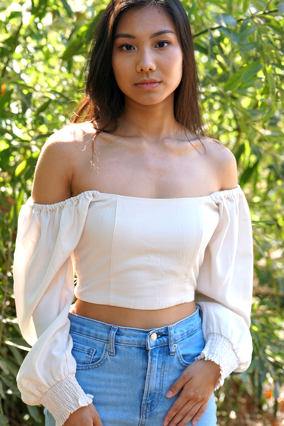 Liv Crop Top in Coconut Milk for women by Paneros Clothing. Square neckline with smocked back and elastic at shoulders, 3/4 length sleeves. 100% Tencel. Front View off shoulders.