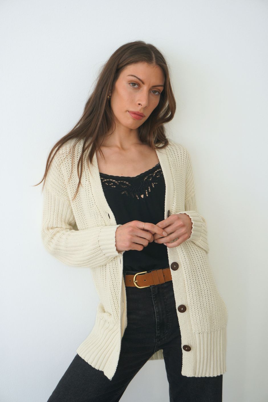 Creamy Off-White Sustainable Cotton Hip-Length Button-up Emily Cardigan by Paneros Clothing. Hand-knitted, slightly oversized cardigan with real coconut shell buttons and ribbed detailing. Front View unbuttoned.