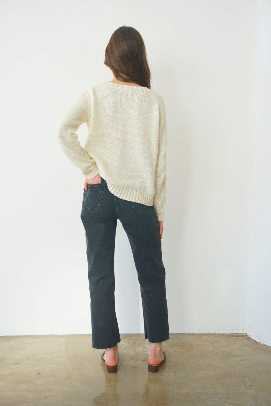 Creamy Off-White sustainable cotton handknitted Sloane Crewneck by Paneros Clothing. Relaxed-fit hip-length crewneck sweater with long sleeves and ribbing details. Back View.