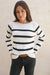 Black and White Striped sustainable cotton handknitted Sloane Crewneck by Paneros Clothing. Relaxed-fit hip-length crewneck sweater with long sleeves and ribbing details. Front View tucked into denim.