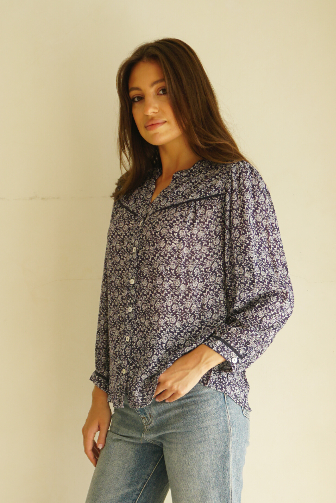 Blue Floral Print Anna Shirt from Paneros Clothing with button-up front and long sleeves. Sustainable rayon dobby shirt blouse in blue floral print with contrast navy piping details. Side View.