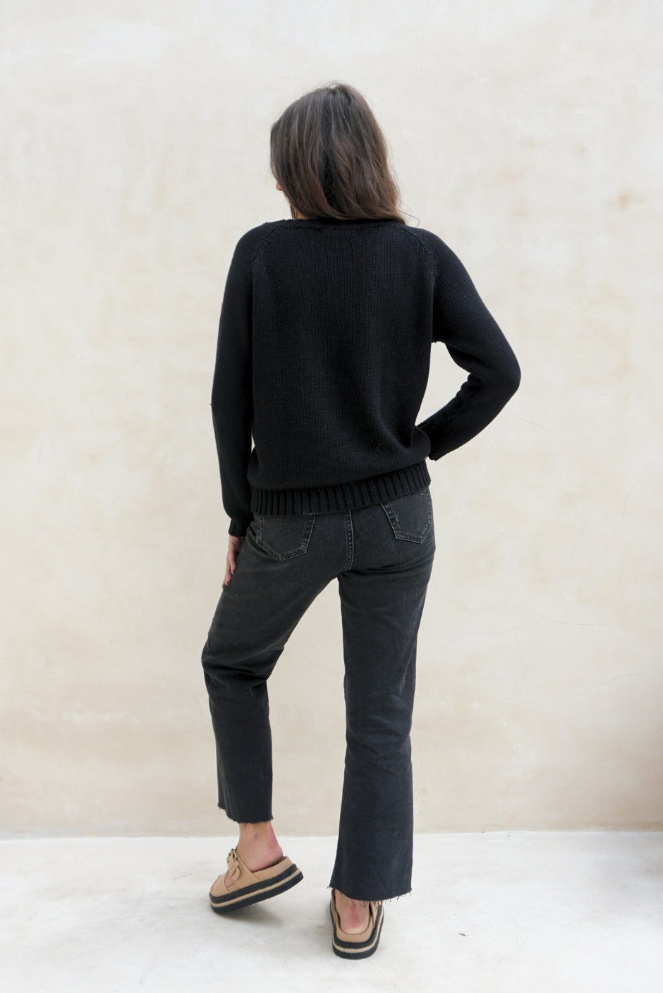 Black sustainable cotton handknitted Sloane Crewneck by Paneros Clothing. Relaxed-fit hip-length crewneck sweater with long sleeves and ribbing details. Back View.