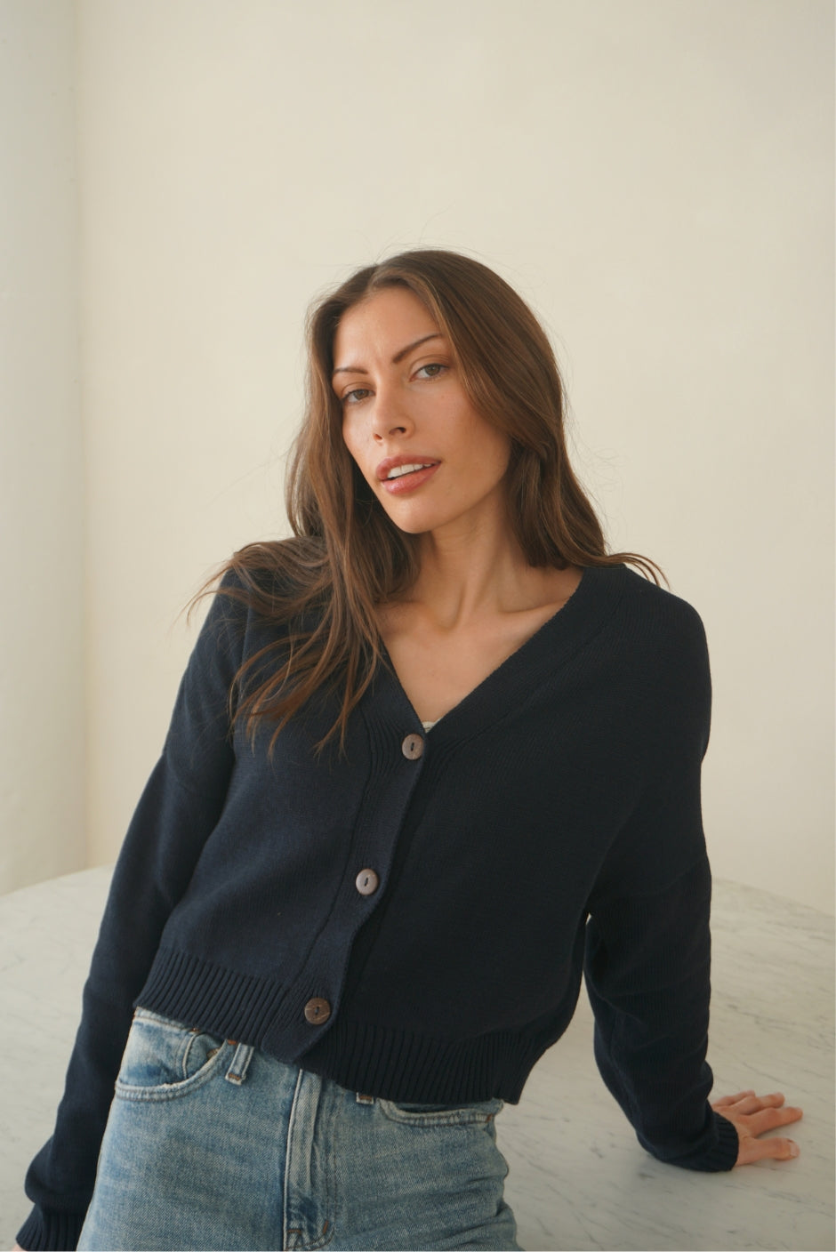 Dark Navy Blue sustainable cropped-length Cotton Diana Cardigan from Paneros Clothing with real coconut shell button-up front, Full sleeves, and feminine handknittting. Front View buttoned.