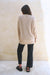 Tan Sustainable Cotton Hip-Length Button-up Emily Cardigan by Paneros Clothing. Hand-knitted, slightly oversized cardigan with real coconut shell buttons and ribbed detailing. Back View.