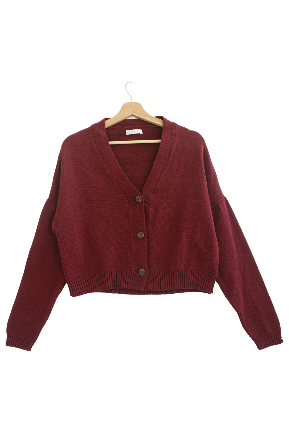 Burgundy sustainable cropped-length Cotton Diana Cardigan from Paneros Clothing with real coconut shell button-up front, Full sleeves, and feminine handknittting. Front View buttoned.