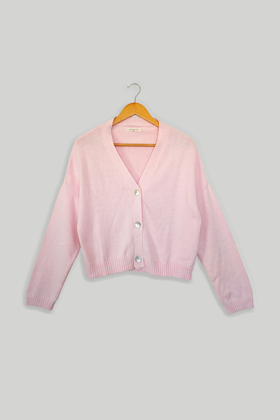 Light Pink sustainable cropped-length Cotton Diana Cardigan from Paneros Clothing with real coconut shell button-up front, Full sleeves, and feminine handknittting. Front View buttoned.