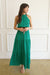 Emerald Green Sustainable Maxi Dress from Paneros Clothing: the Gia. Halter neckline, elastic at the waist, with ruffles.  Front View walking showing the flowy rayon tiered skirt.