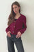 Burgundy sustainable cropped-length Cotton Diana Cardigan from Paneros Clothing with real coconut shell button-up front, Full sleeves, and feminine handknittting. Front and Side View in motion, buttoned