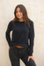 Navy Blue sustainable cotton handknitted Sloane Crewneck by Paneros Clothing. Relaxed-fit hip-length crewneck sweater with long sleeves and ribbing details. Front View tucked into denim.