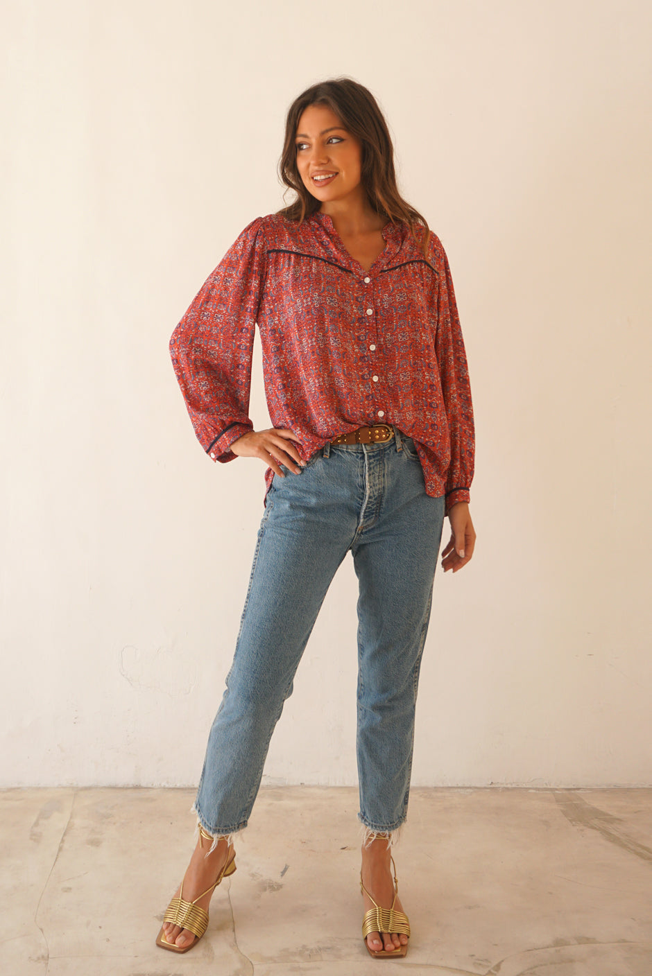 Red Boho Print Spring/Summer 2023 Anna Shirt from Paneros Clothing with button-up front and long sleeves. Full Front View tucked into denim.