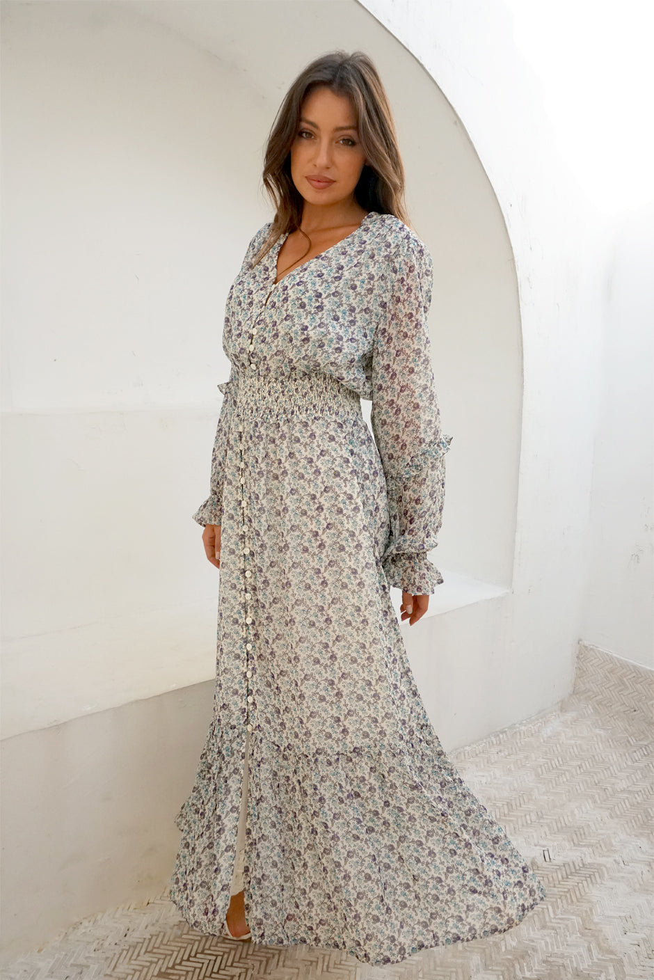 White/Blue/Purple Floral Print Long Sleeve Women&#39;s Aria Ankle-lenght Maxi Dress from Paneros Clothing with 100% certified sustainable fabric, ruffles, button-up front, and smocking. Front View.