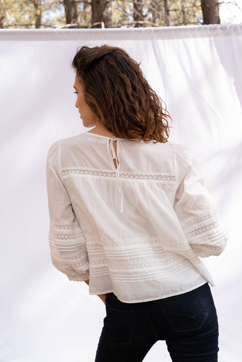 Cloud White Long Sleeve Dawn Blouse for women by Paneros Clothing. Handmade from soft cotton voile with pin tucks and lace trim. Back View.