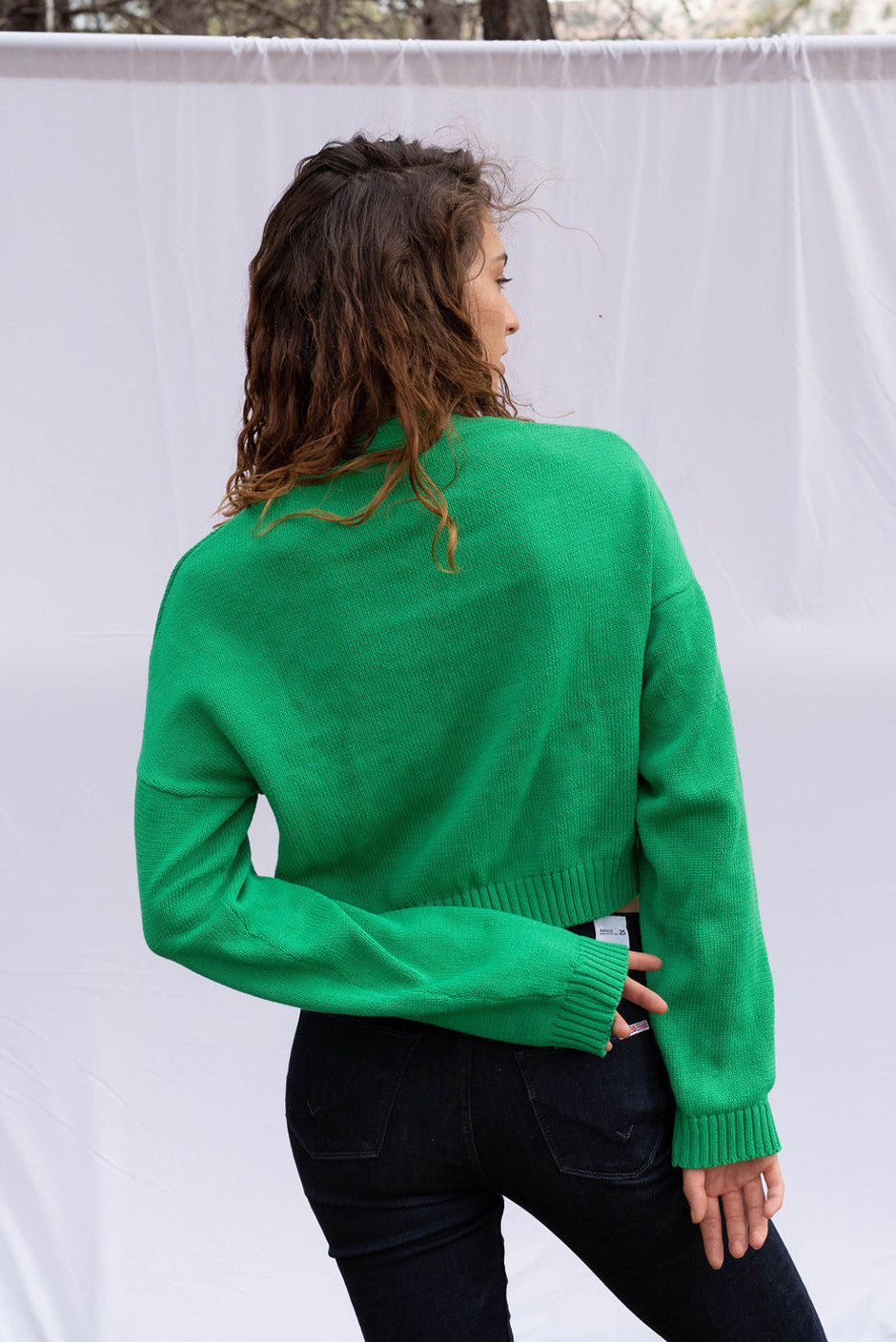 Diana cropped Cardigan in Emerald Green color for women by Paneros Clothing. Handknitted from sustainable deadstock cotton yarn, with full sleeves and vintage crystal buttons. Back view.