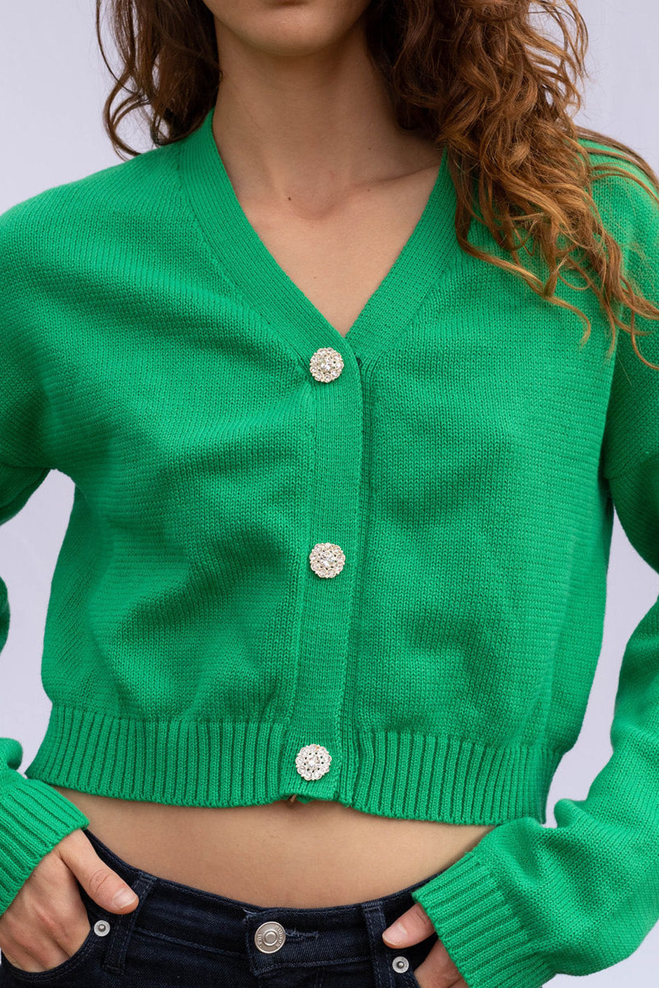 Diana cropped Cardigan in Emerald Green color for women by Paneros Clothing. Handknitted from sustainable deadstock cotton yarn, with full sleeves and vintage crystal buttons. Front crop detail view.