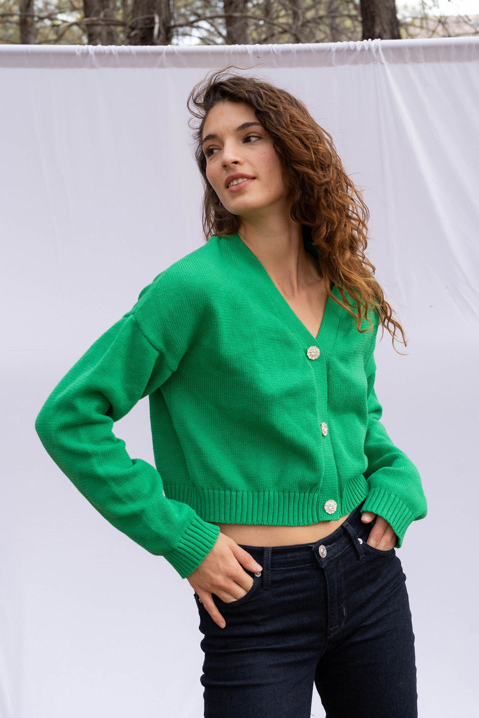 Diana cropped Cardigan in Emerald Green color for women by Paneros Clothing. Handknitted from sustainable deadstock cotton yarn, with full sleeves and vintage crystal buttons. Front view.