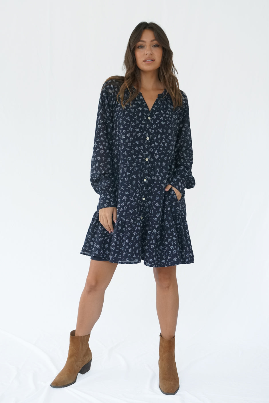 Floral Print Long Sleeve Women's Ella Above-the-Knee Mini Dress from Paneros Clothing with 100% certified sustainable fabric and smocking. Front View with loose waist & button front hand in pocket.