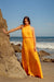 Gia Maxi Dress in Mango Orange for women by Paneros Clothing. Lifestyle scene.