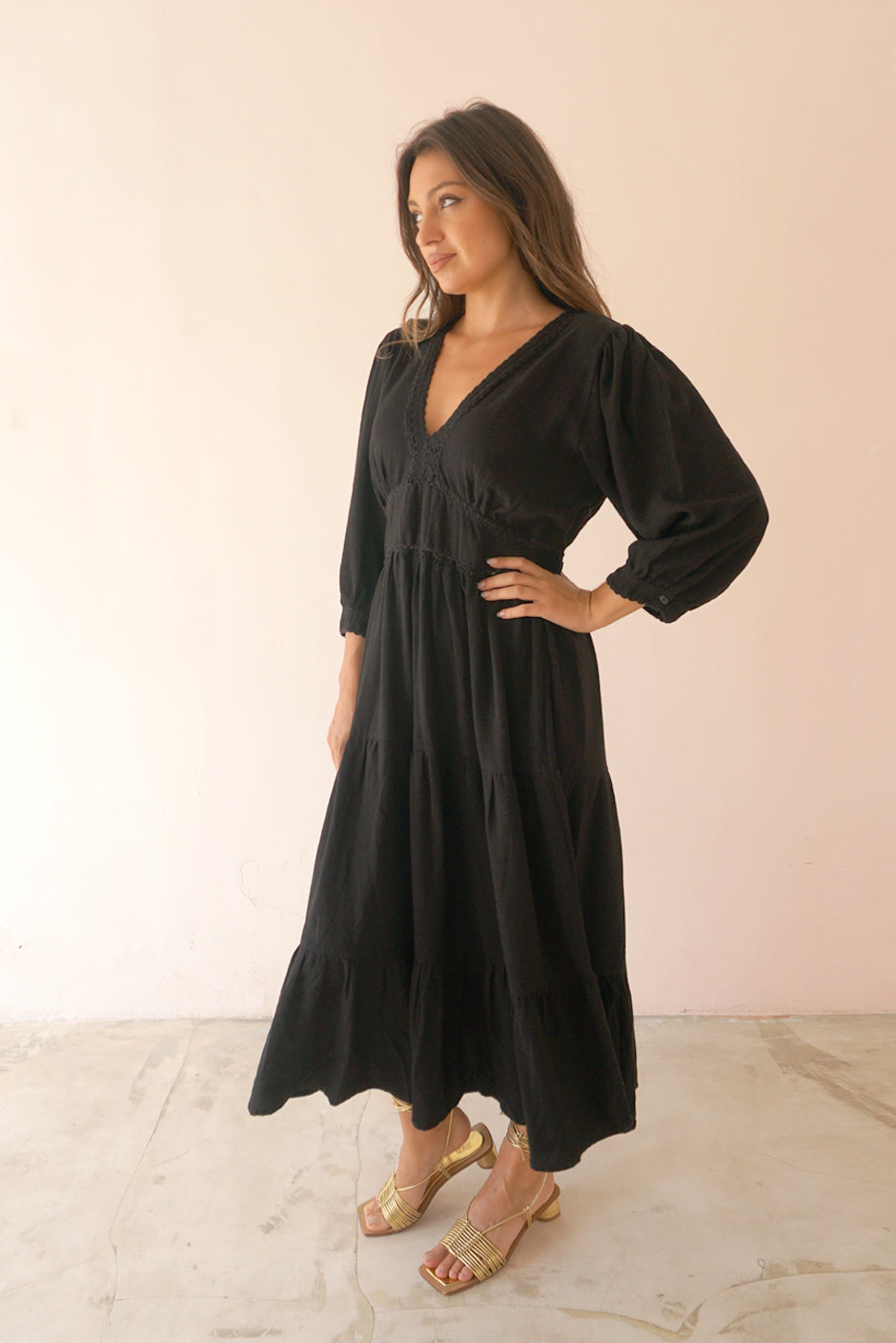 Black Crochet 3/4 Sleeve Women's Maya Below-the-knee Midi Dress from Paneros Clothing with 100% certified sustainable fabric, embroidery, and smocking. Side View.