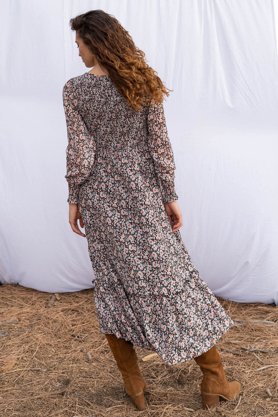 Stella Midi dress in tossed ditsy floral print for women by Paneros Clothing. From sustainable deadstock silk fabric, with smocking ruffles and sleeves. Back side view.