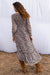 Stella Midi dress in tossed ditsy floral print for women by Paneros Clothing. From sustainable deadstock silk fabric, with smocking ruffles and sleeves. Back side view.