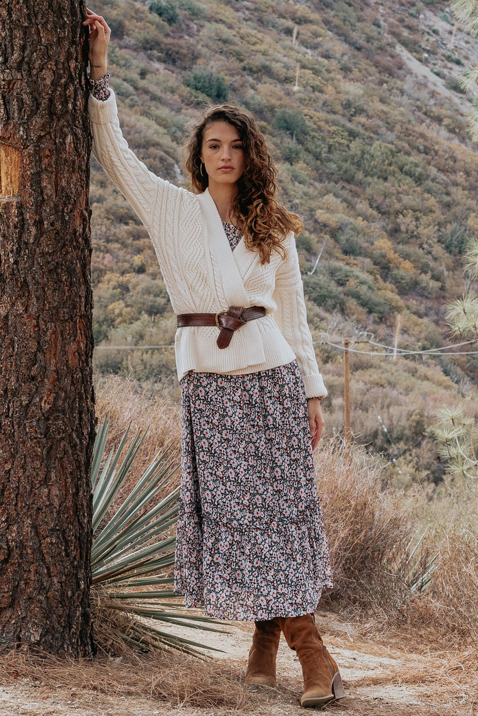 Stella Midi dress in tossed ditsy floral print for women by Paneros Clothing. From sustainable deadstock silk fabric, with smocking ruffles and sleeves. Front view styled with Cardigan.