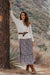 Stella Midi dress in tossed ditsy floral print for women by Paneros Clothing. From sustainable deadstock silk fabric, with smocking ruffles and sleeves. Front view styled with Cardigan.