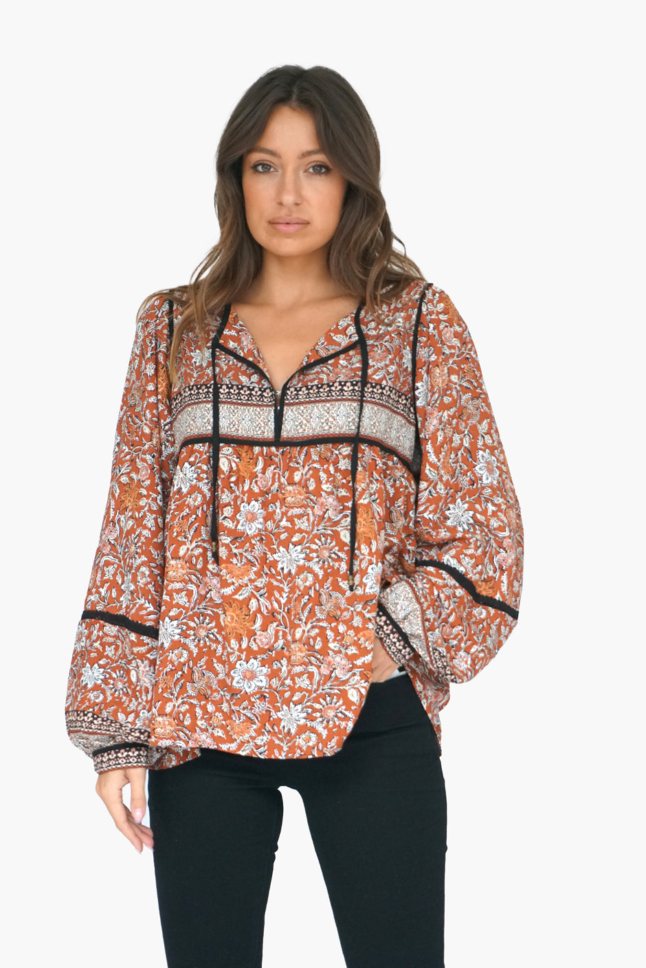 Bohemian Brown Floral Print Long Sleeve Women's Sierra Blouse Top from Paneros Clothing with 100% certified sustainable fabric and contrast black binding & open neck. Front View untucked Loose with black jeans.