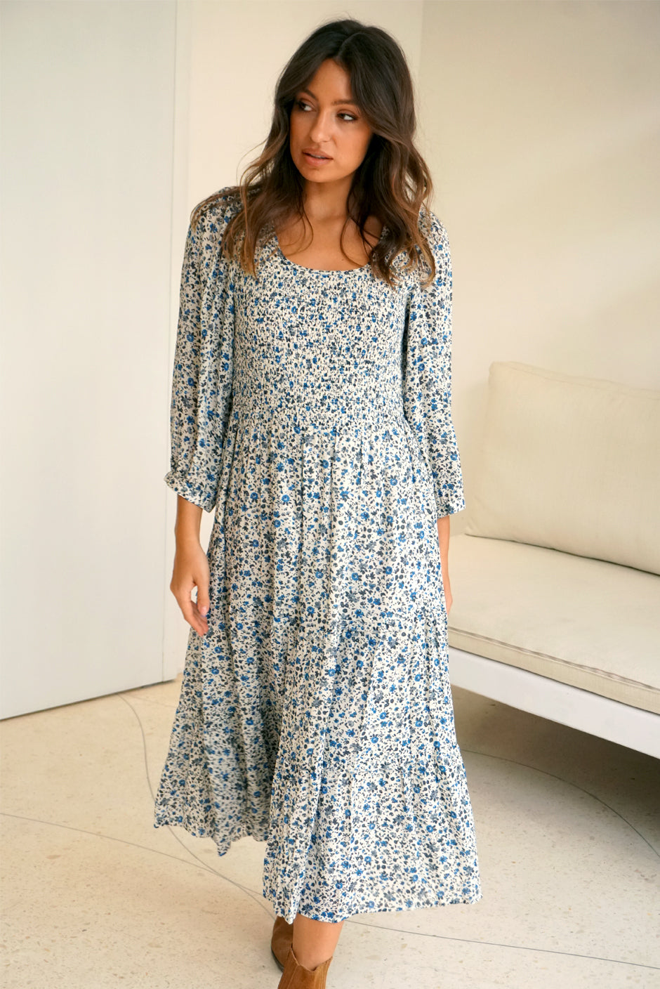 Floral Print Long Sleeve Women's Stella Below-the-Knee Midi Dress from Paneros Clothing with 100% certified sustainable fabric and smocking. Front View walking.