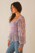 Purple Pink Floral Print Blouse Top for Women with smocking, ruffle details, and full length sleeves from Paneros Clothing: the Stella Top. Side View.