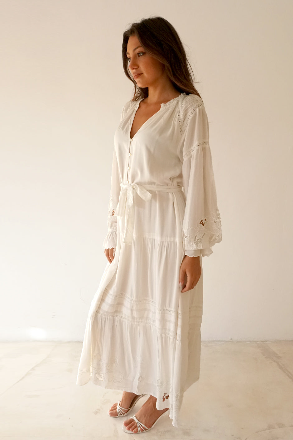 White Button-up Midi Dress for Women with lace and embroidery details in the sleeves and skirt, full length sleeves from Paneros Clothing: the Stevie Dress. Side View with embroidery details.