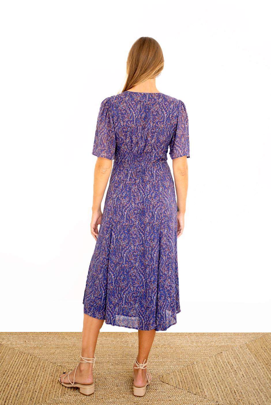 Purple Boho Print Spring/Summer 2022 Aurora Midi Dress from Paneros Clothing with V-neckline and mid sleeves and Piping detail. Back View with stretchy smocking detail.