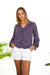 Purple Boho Print Spring/Summer 2022 Aria Blouse from Paneros Clothing with V-neckline and long sleeves. Side View untucked with White Shorts.