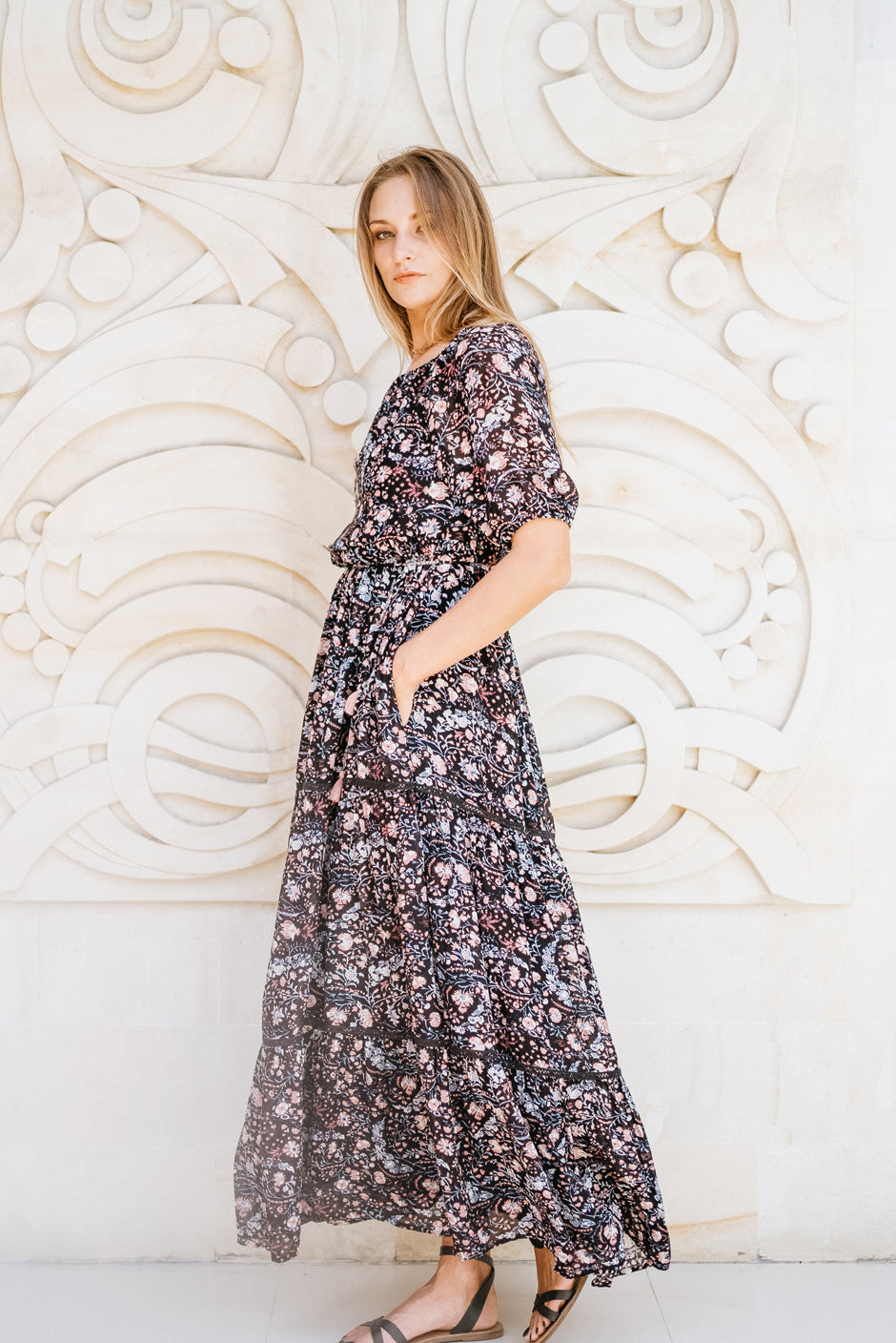 Purple/Blue/Pink Bohemian Floral Paisley Print Spring/Summer 2022 Ethical Sustainable Elegant Luxury Fashion Jessa Maxi Dress from Paneros Clothing. Side View with stretchy smocking at waist and border details. Styled on-the-shoulders.
